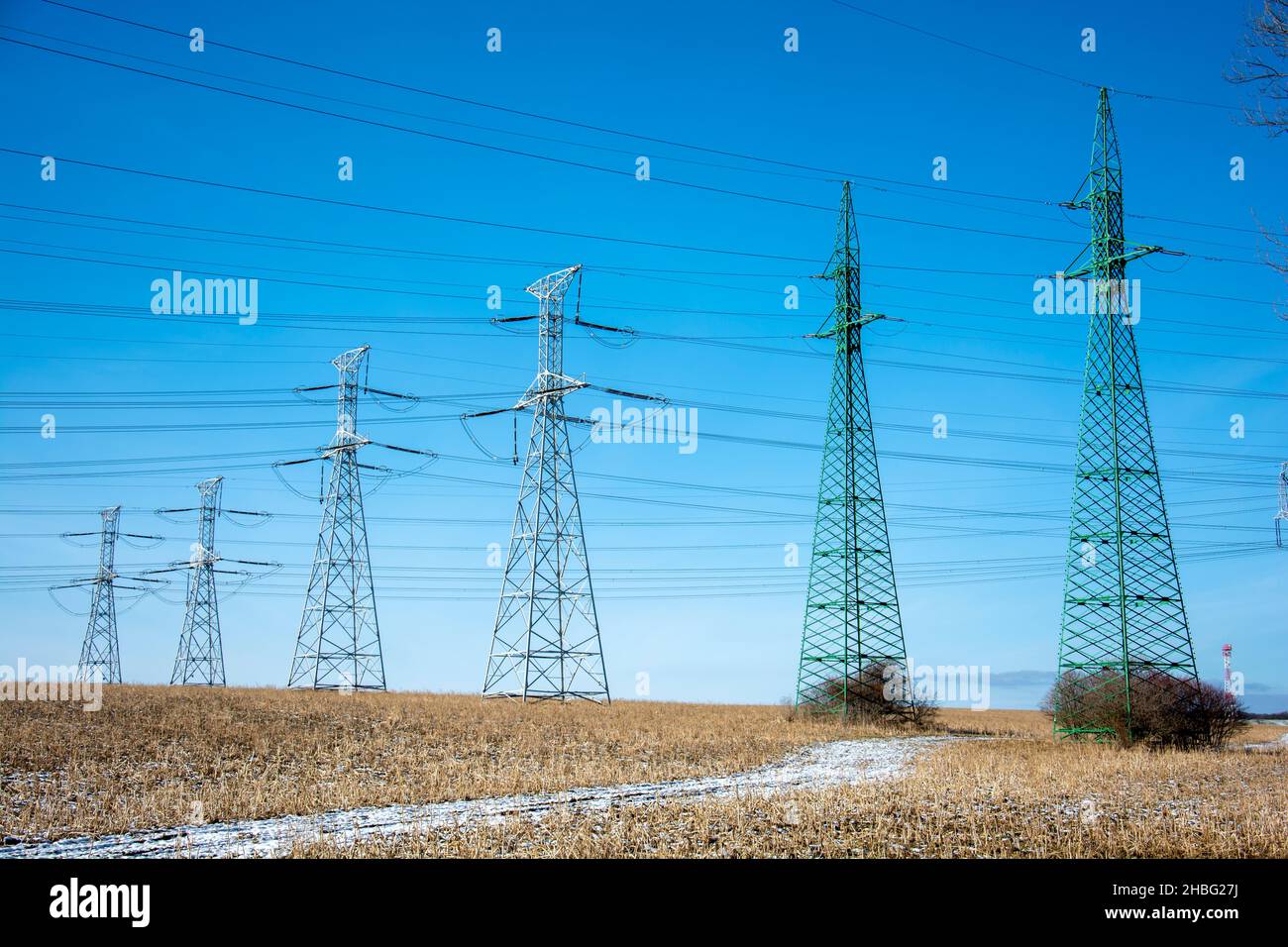 High voltage power lines and power pylons in the agricultural field ...