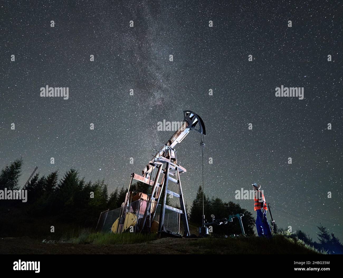 Side view of professional technician in uniform and helmet looking at