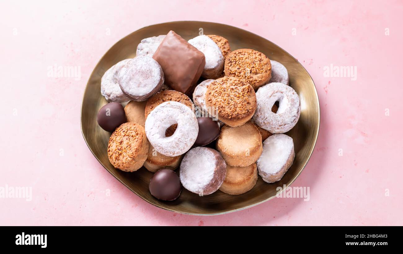 Holiday delicacies polvorones and mantecados in golden plate on pink table, top view Stock Photo