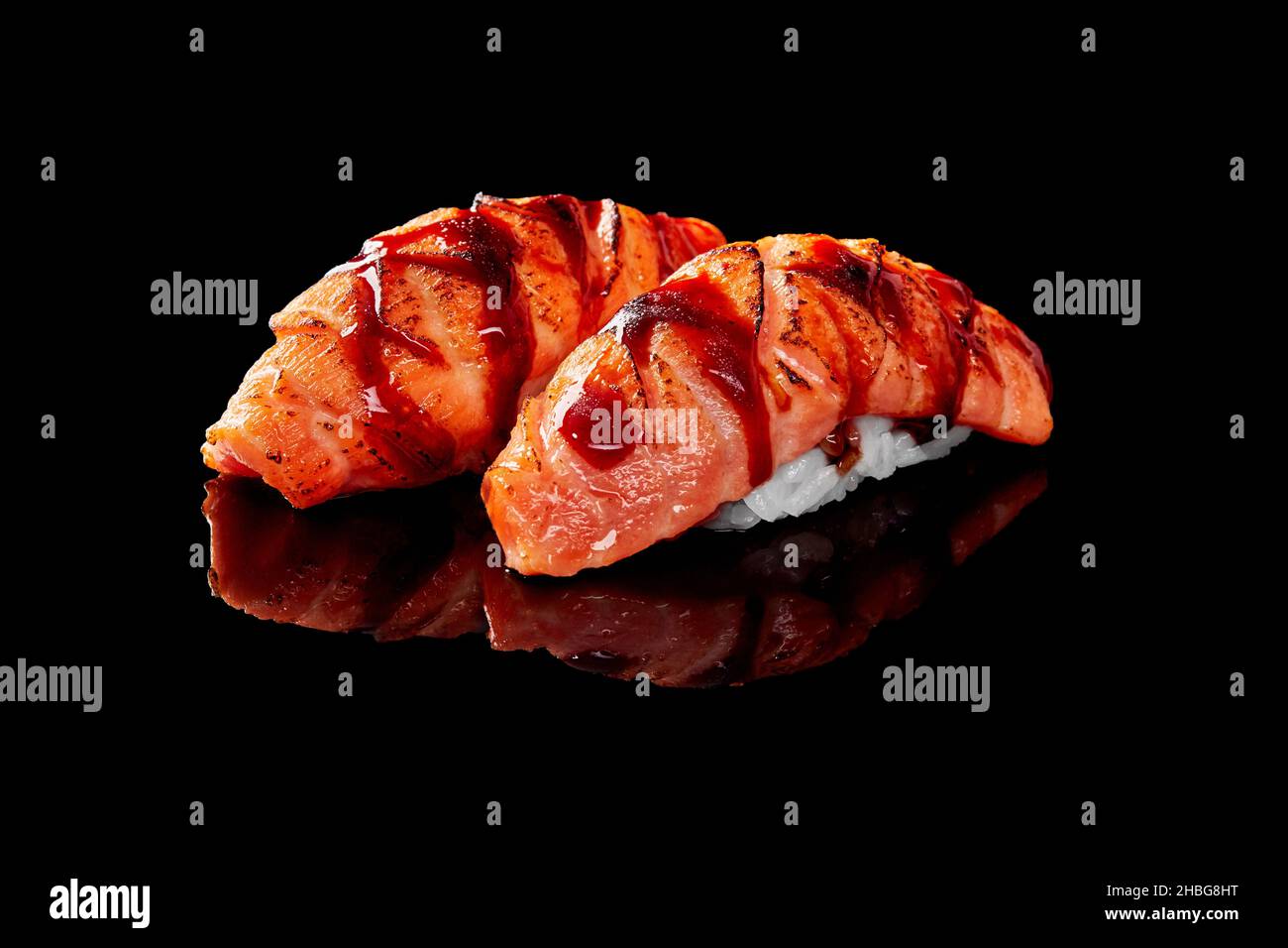 Closeup of nigiri sushi with seared salmon and unagi sauce isolated on