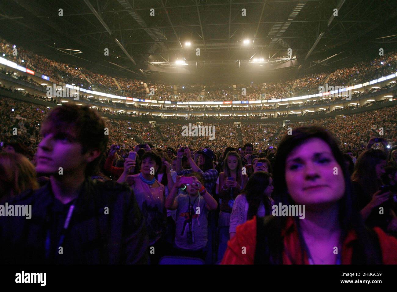 Fans watch Justin Bieber perform on stage at the O2 Arena in London ...