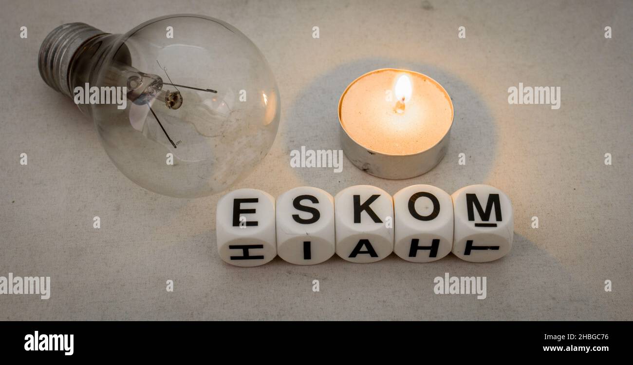 The term Eskom, a fused electric bulb and a small candle isolated on a clear background Stock Photo