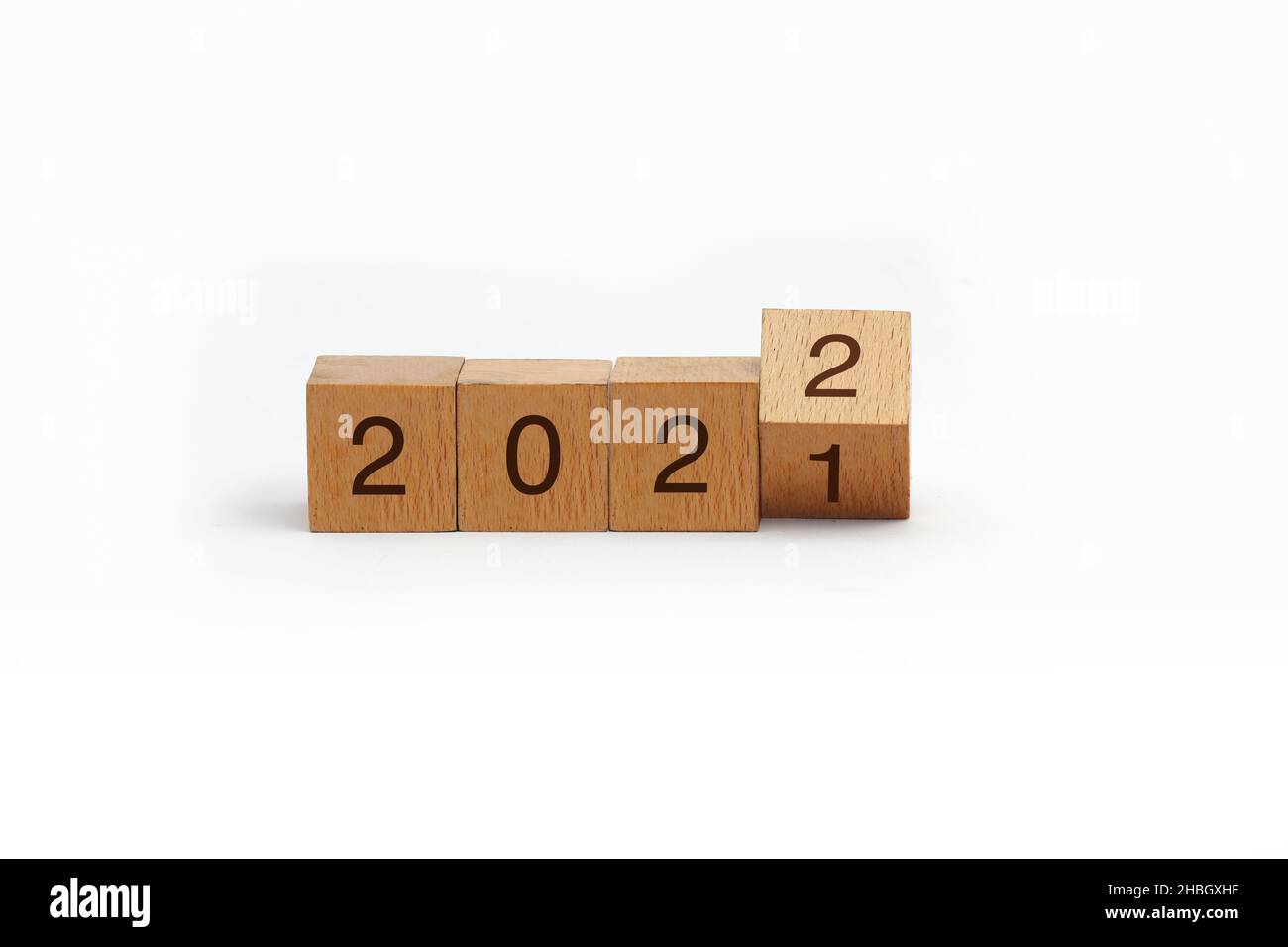 flipping cubes with year 2021 to 2022. new year concept. copy space. 3D wooden cube flip over wooden block isolated in white background Stock Photo