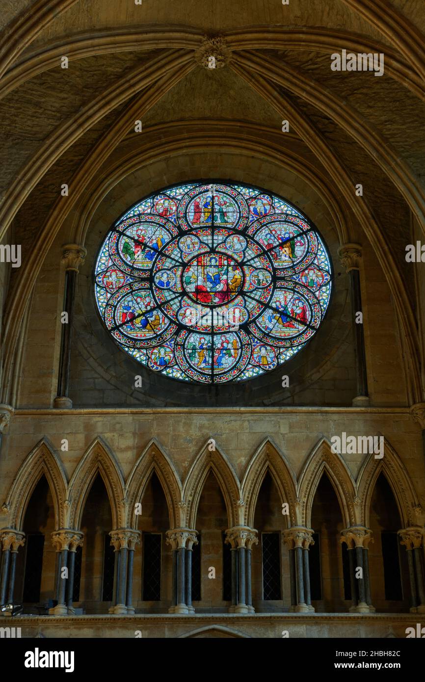 Circular stained glass window above pointed arches over the entrance to