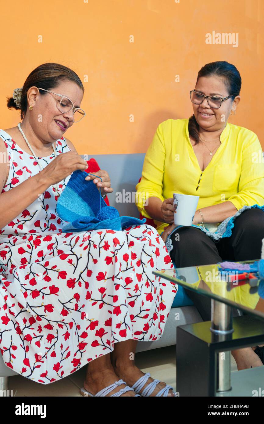 Mature Latin women knitting at home Stock Photo