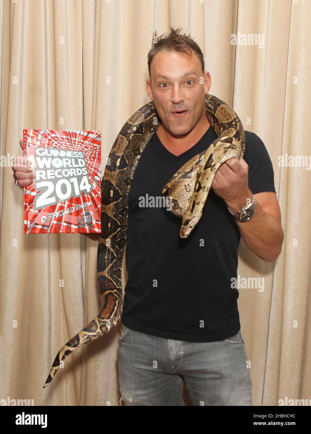 Tobis Anstis holding Belle the worlds longest living boa constrictor at the Guinness Book of Records 2014 Launch Party at One Marylebone in London. Stock Photo