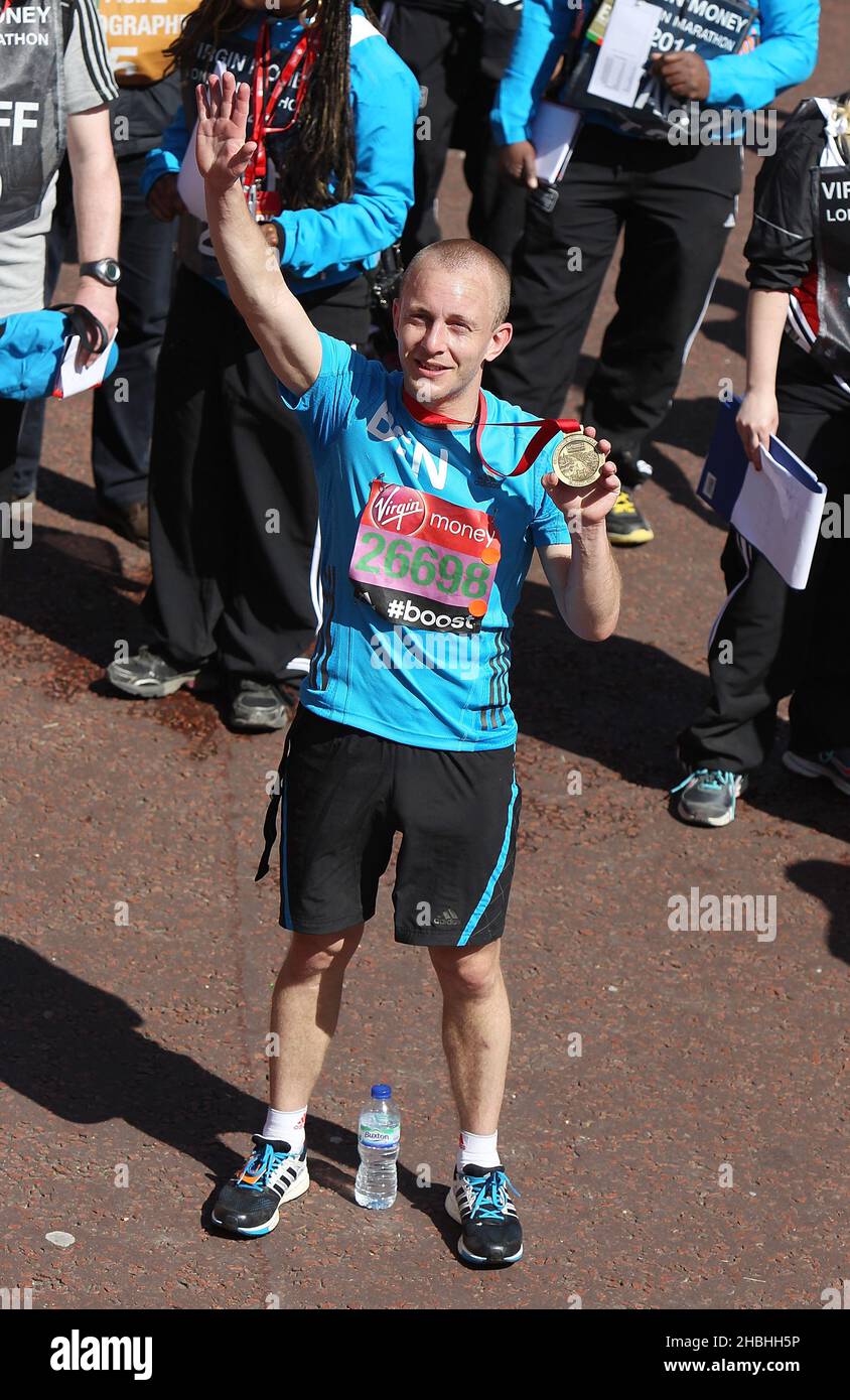 Ben Quilton with medal at the finishing line of the Virgin Money London Marathon on the Mall in London. Stock Photo