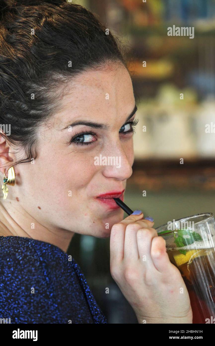 Young woman drinks ice tea with a straw Stock Photo