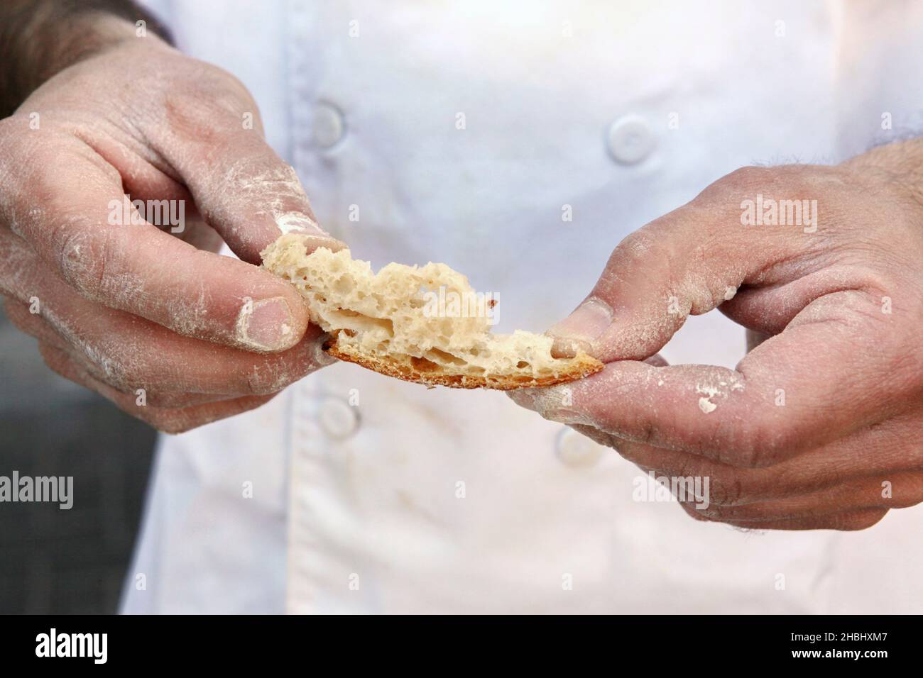 Baking Concept - baker inspects the baked bread Stock Photo