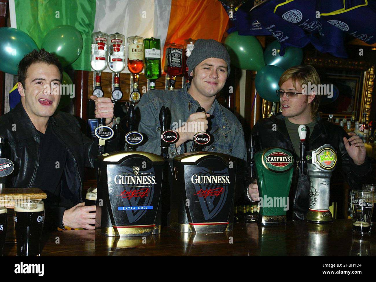 Westlife pulling pints at the O'Neills Pub in Wardour St, on St Patricks Day, London 3/4 length Stock Photo
