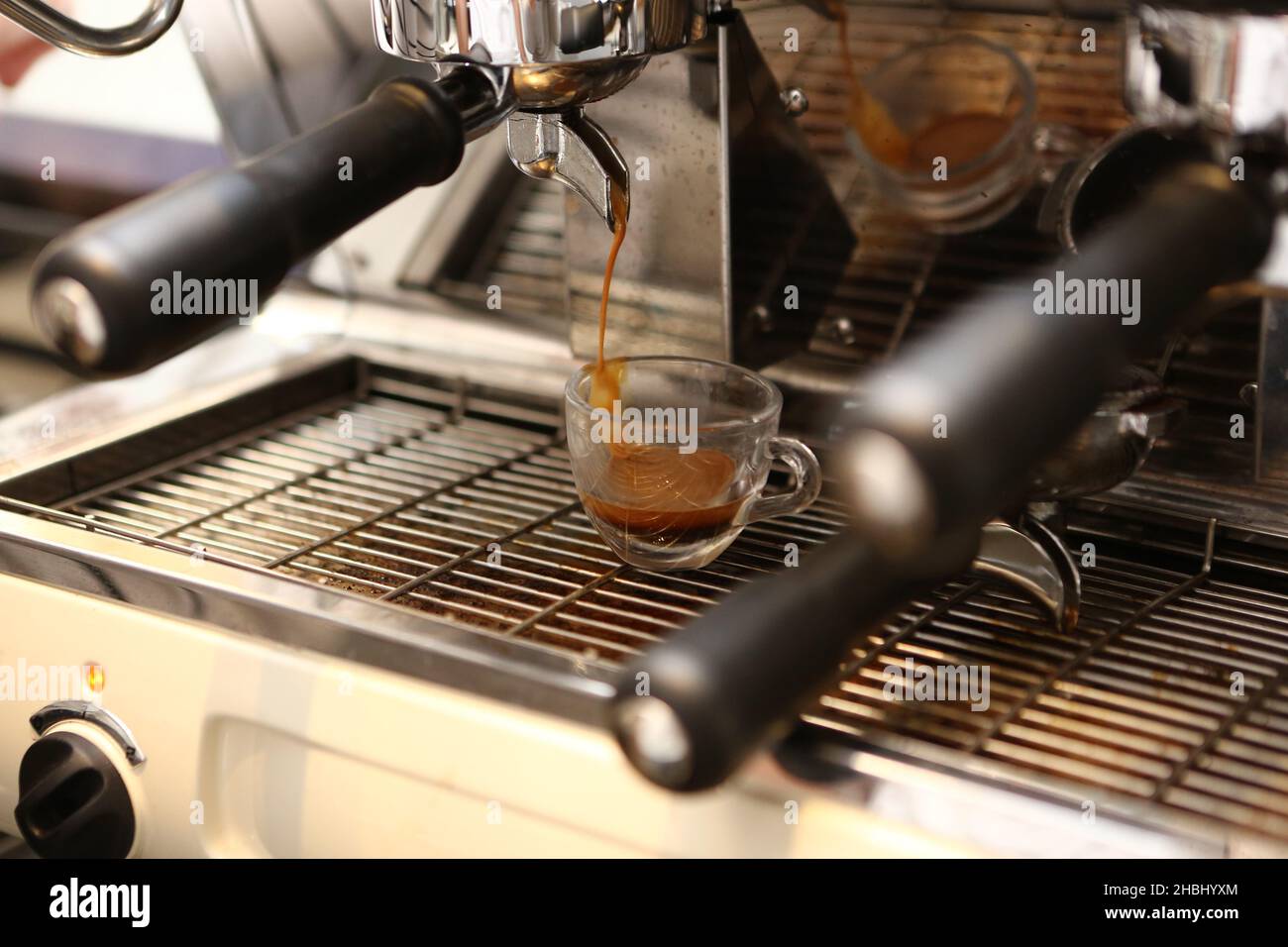 Two espresso cups getting filled in a portafilter machine Stock Photo -  Alamy