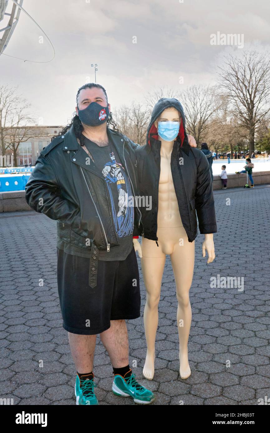 A bizarre photo of a man with what appears to be a male mannequin dressed as a woman. In a park in Queens New York City. Stock Photo