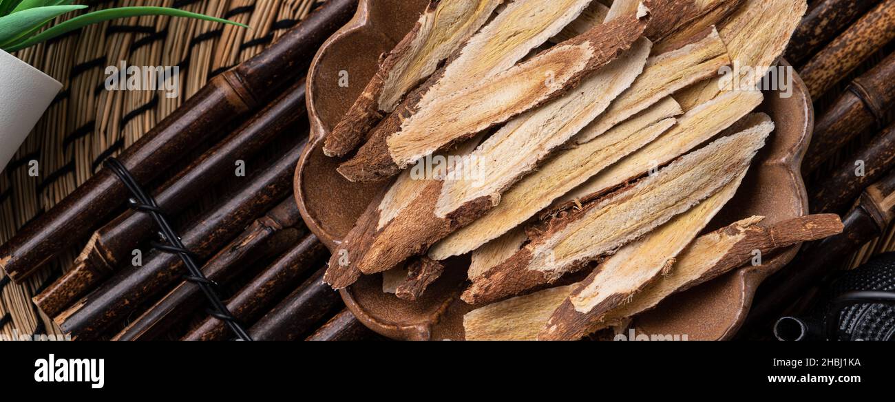 Top view of Chinese traditional herbal medicine Astragalus root on wooden table background. Stock Photo