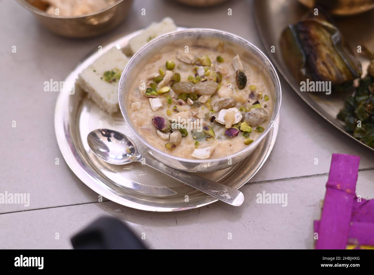 Click of a Kheer sweet in a bowl with a plate and a spoon kept on the ...