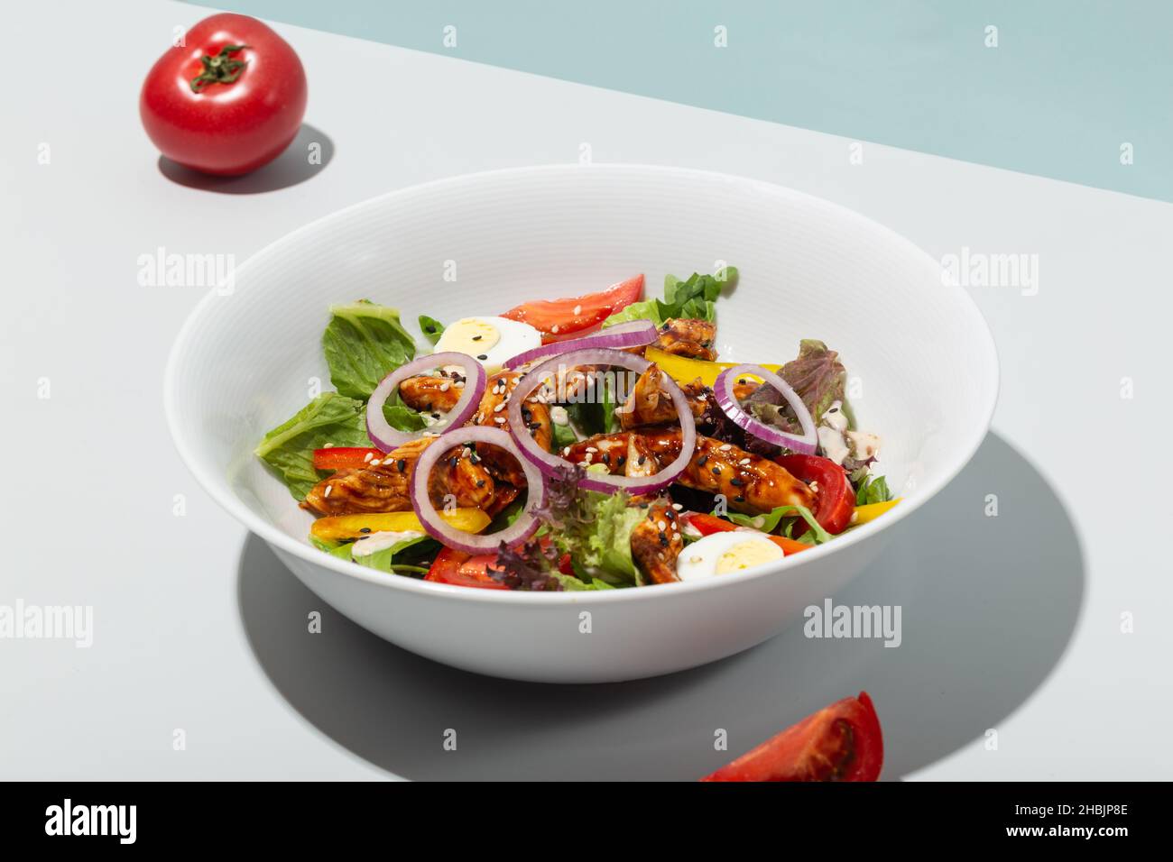 Salad with grilled eel and vegetables tomatoes onion eggs hard shadows modern Stock Photo