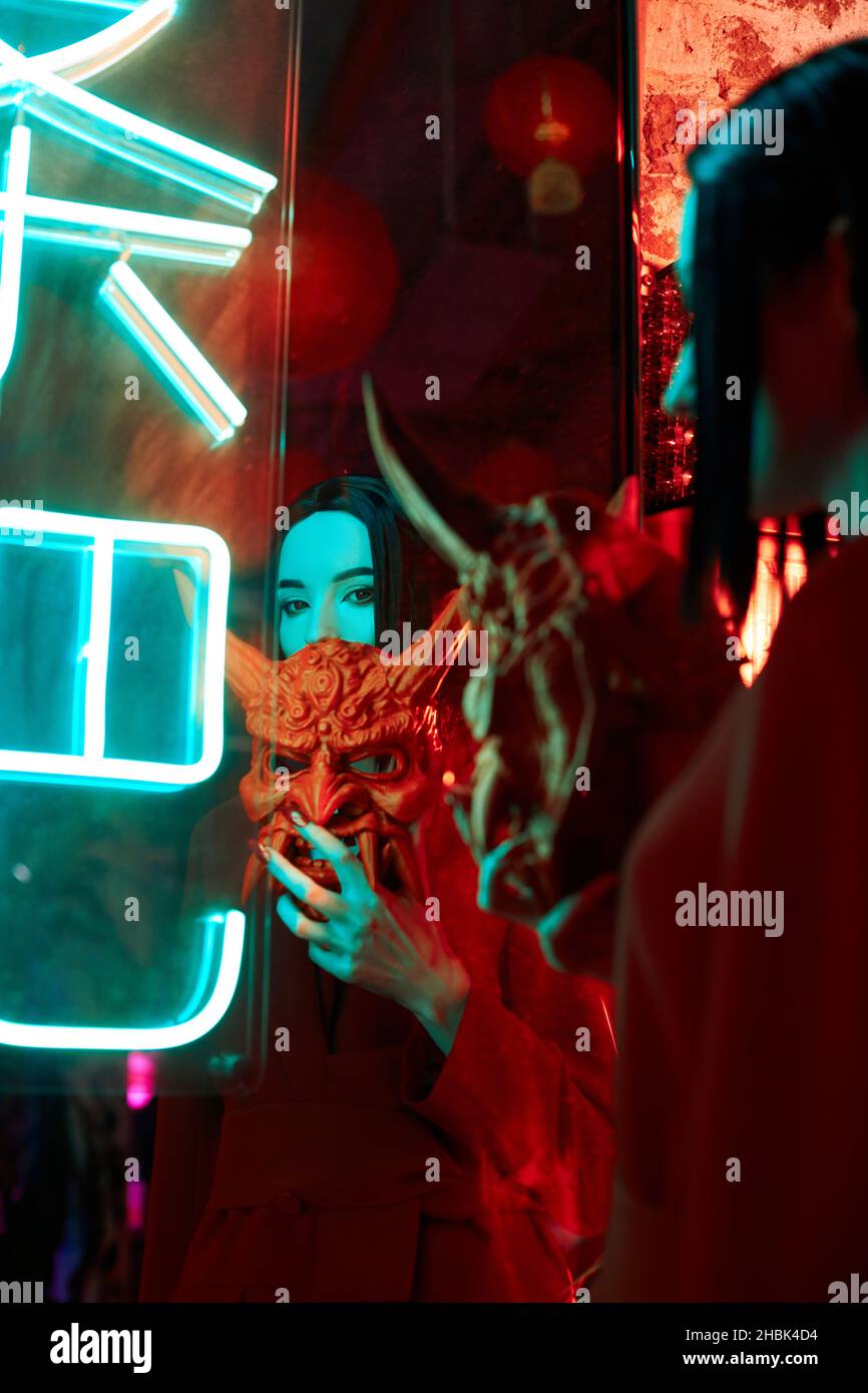 Anime woman in a red suit with short hair cut, black hair. A killer