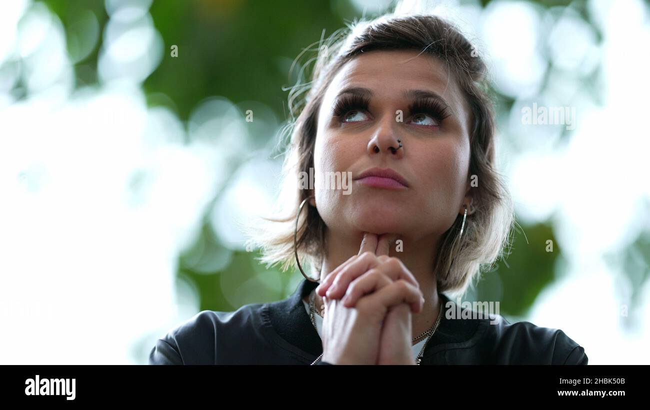 Pensive woman contemplating decision outside. authentic thinking ...