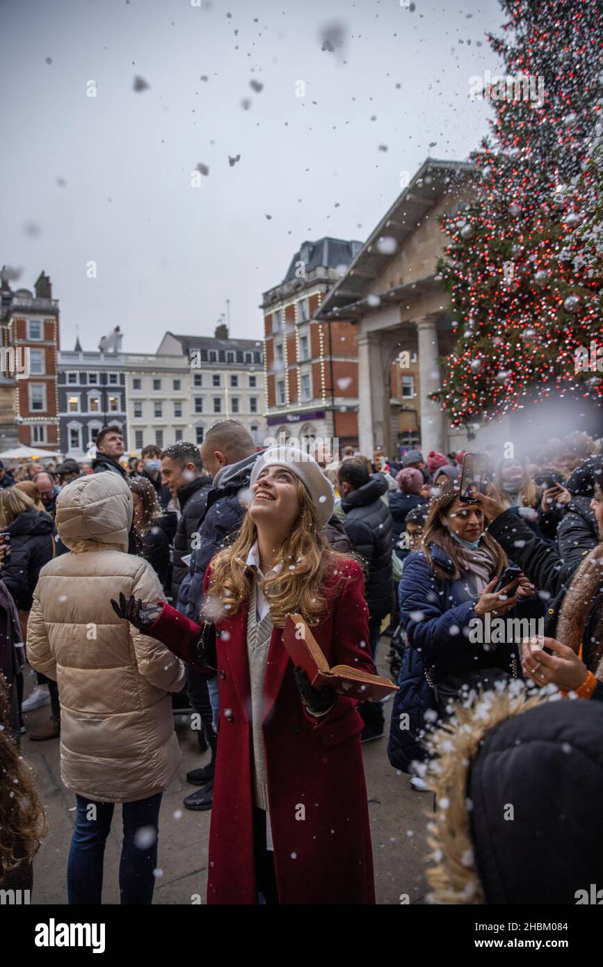 Christmas shoppers embrace the fake snow in Covent Garden Piazza whilst