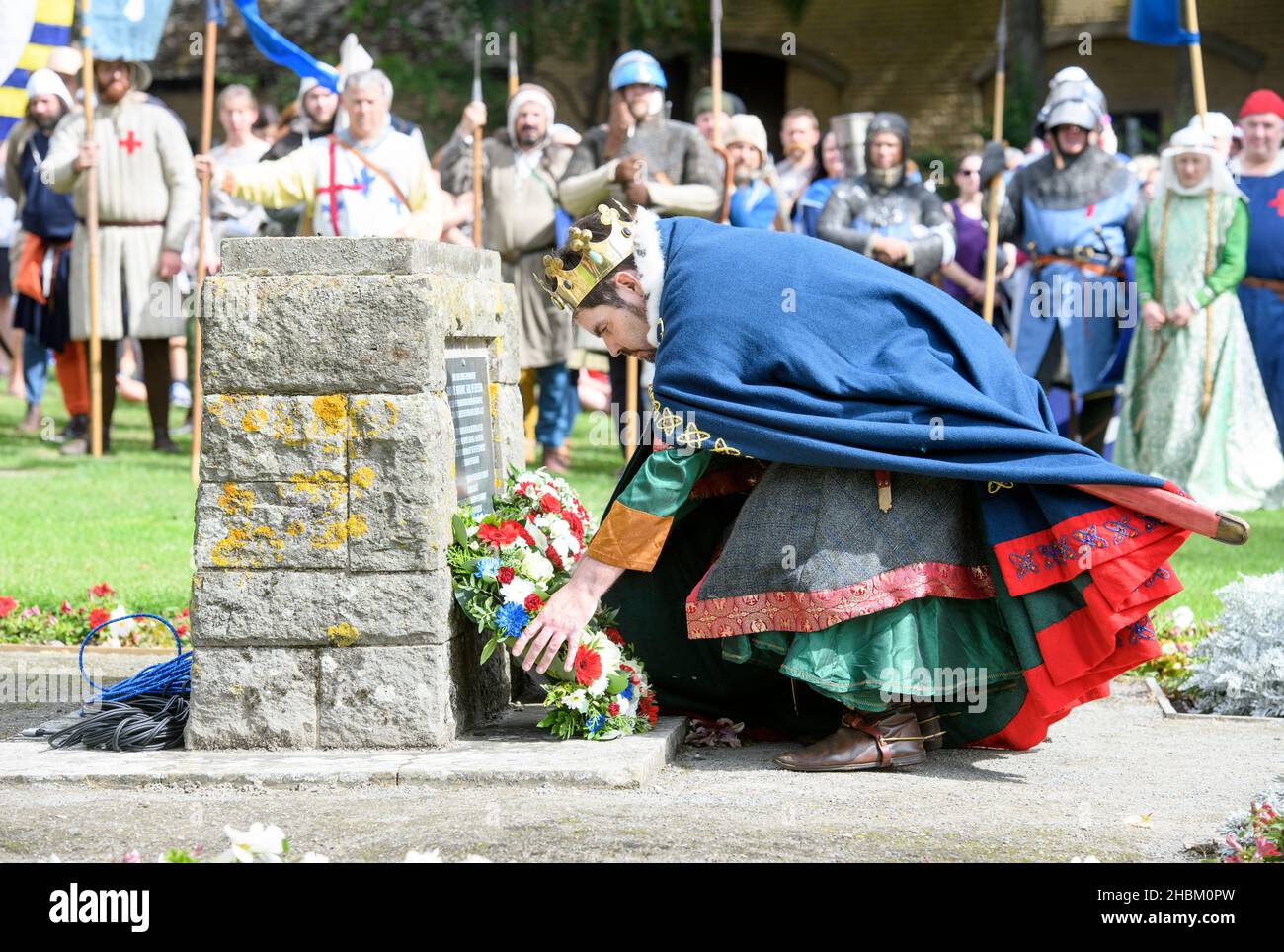 A medieval actor lays a wreath at the Simon de Montfort memorial at Abbey Ground before a later re-enactment of The Battle of Evesham. Stock Photo