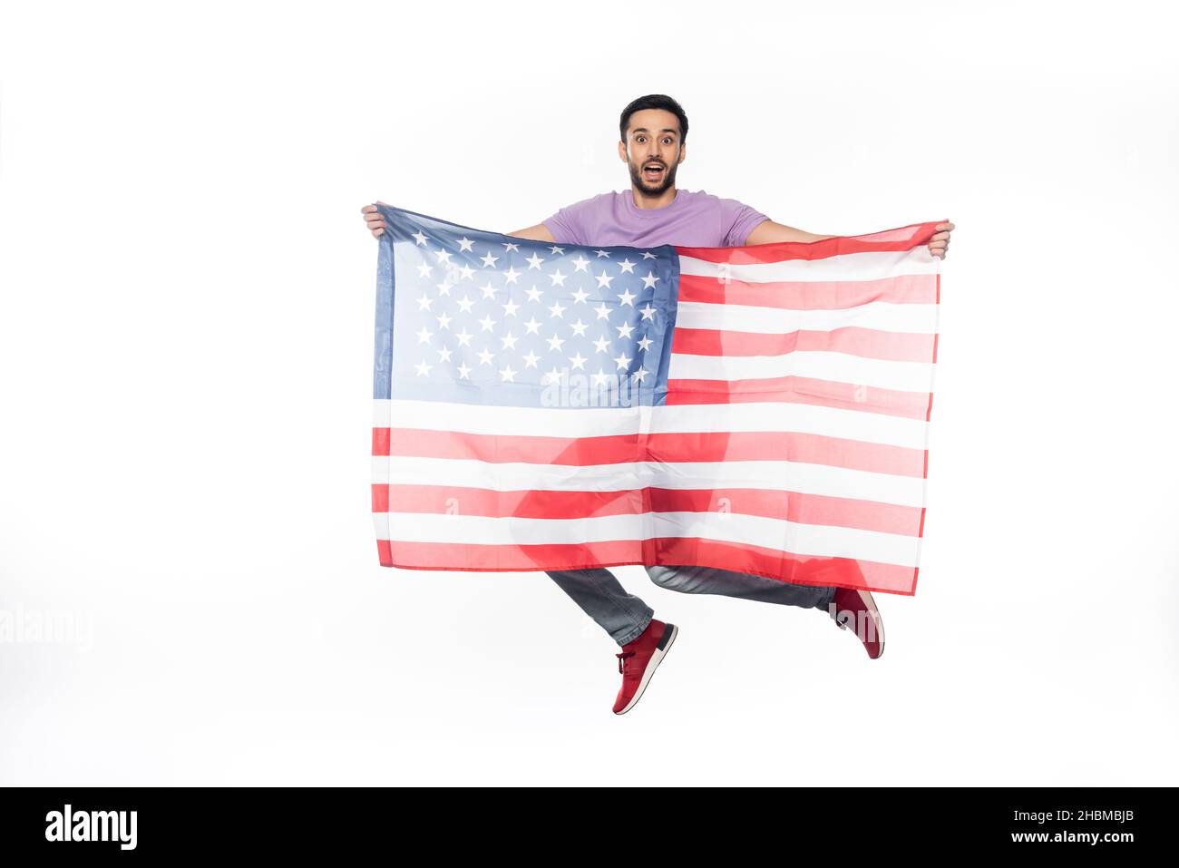 positive and patriotic man jumping with american flag isolated on white Stock Photo