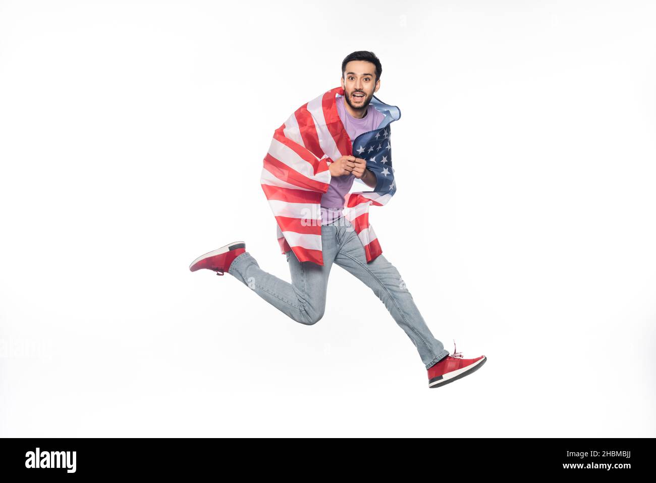 happy and patriotic man jumping with american flag isolated on white Stock Photo