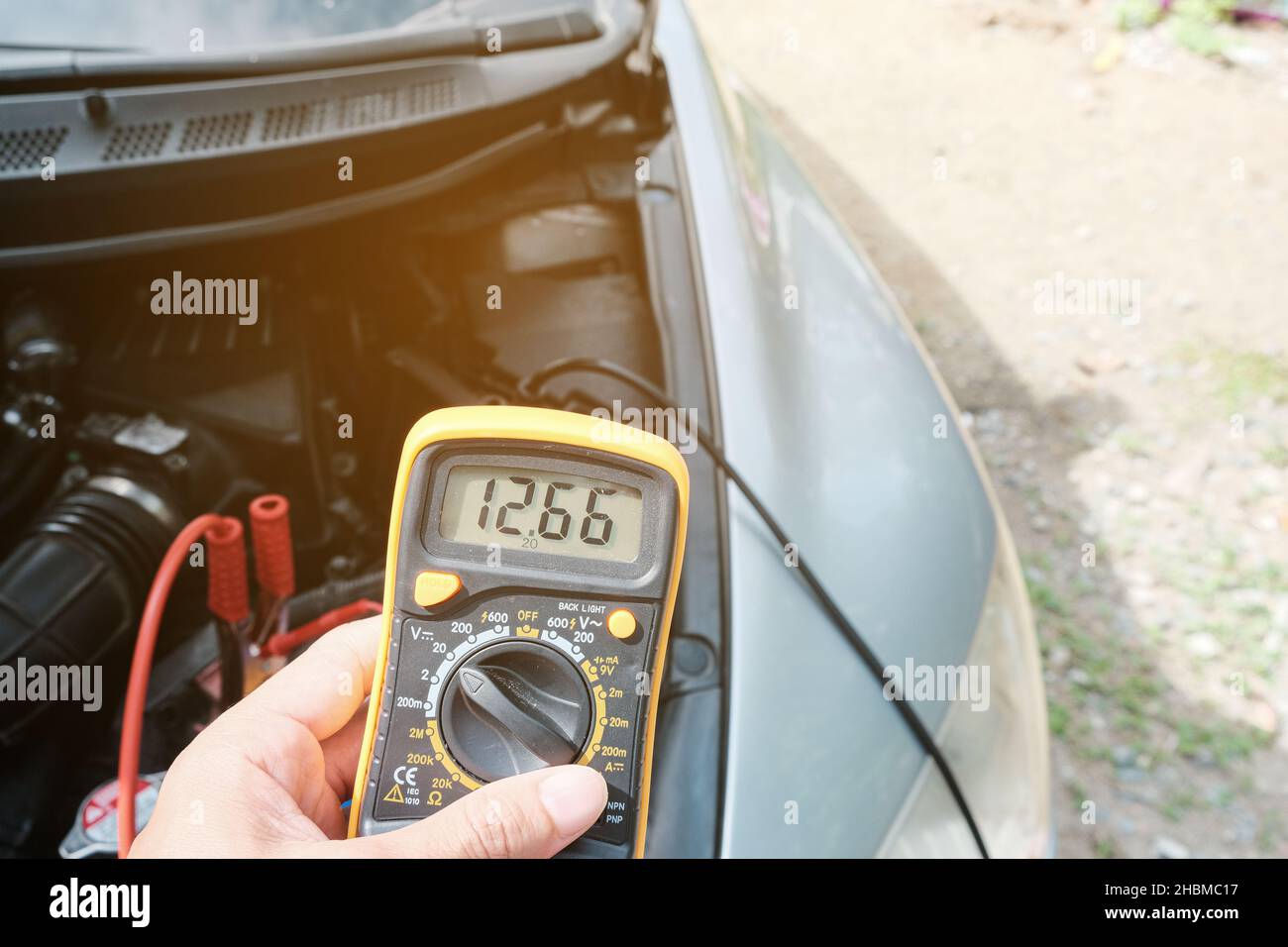 Mechanicl man uses electric multimeter voltmeter to check the voltage