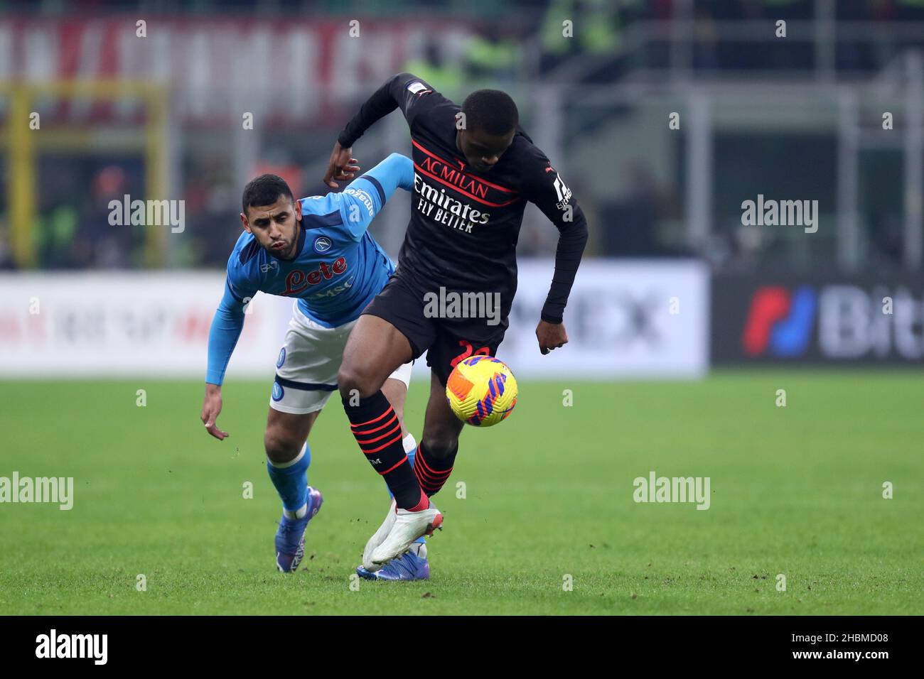 Pierre Kalulu of Ac Milan and Faouzi Ghoulam of Ssc Napoli  battle for the ball during the Serie A match between Ac Milan and Ssc Napoli at Stadio Giuseppe Meazza on December 19, 2021 in Milan, Italy. Stock Photo