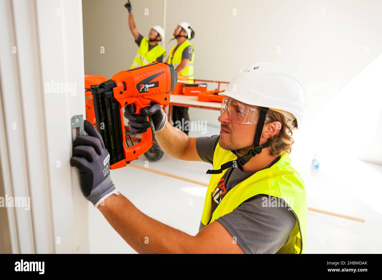 Carpenter using gaspowered nailgun Stock Photo Alamy