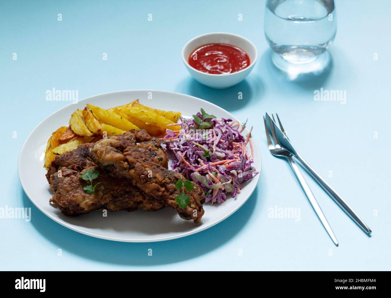 A traditional American dinner of fried ribs, fried potatoes and coleslaw. Stock Photo