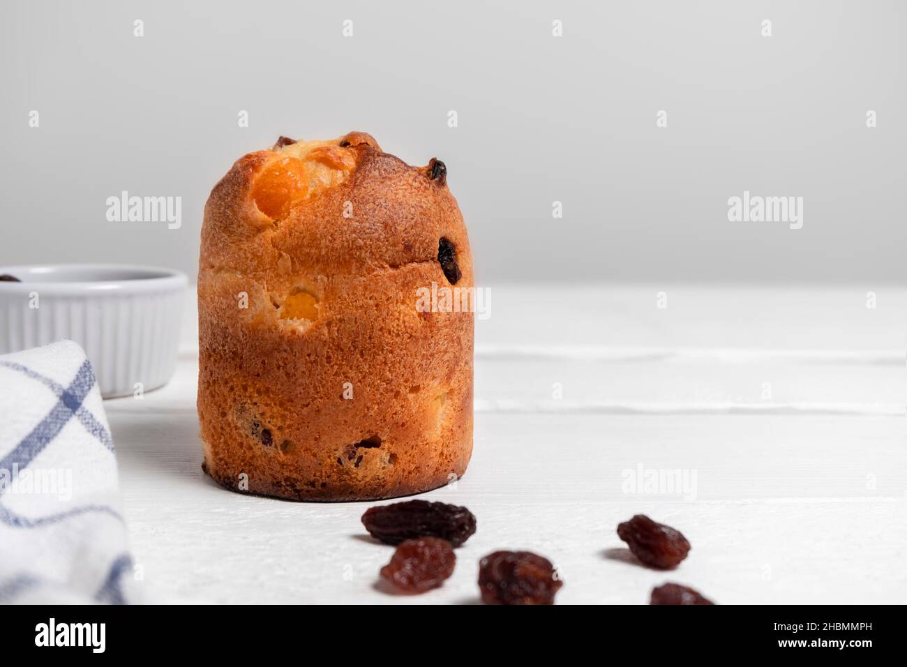 Festive Christmas dessert Panettone with raisins on white wooden background with copy space Stock Photo