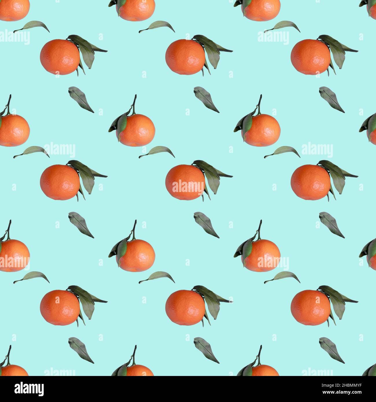 Tangerines seamless pattern with green leaves on light blue background Stock Photo