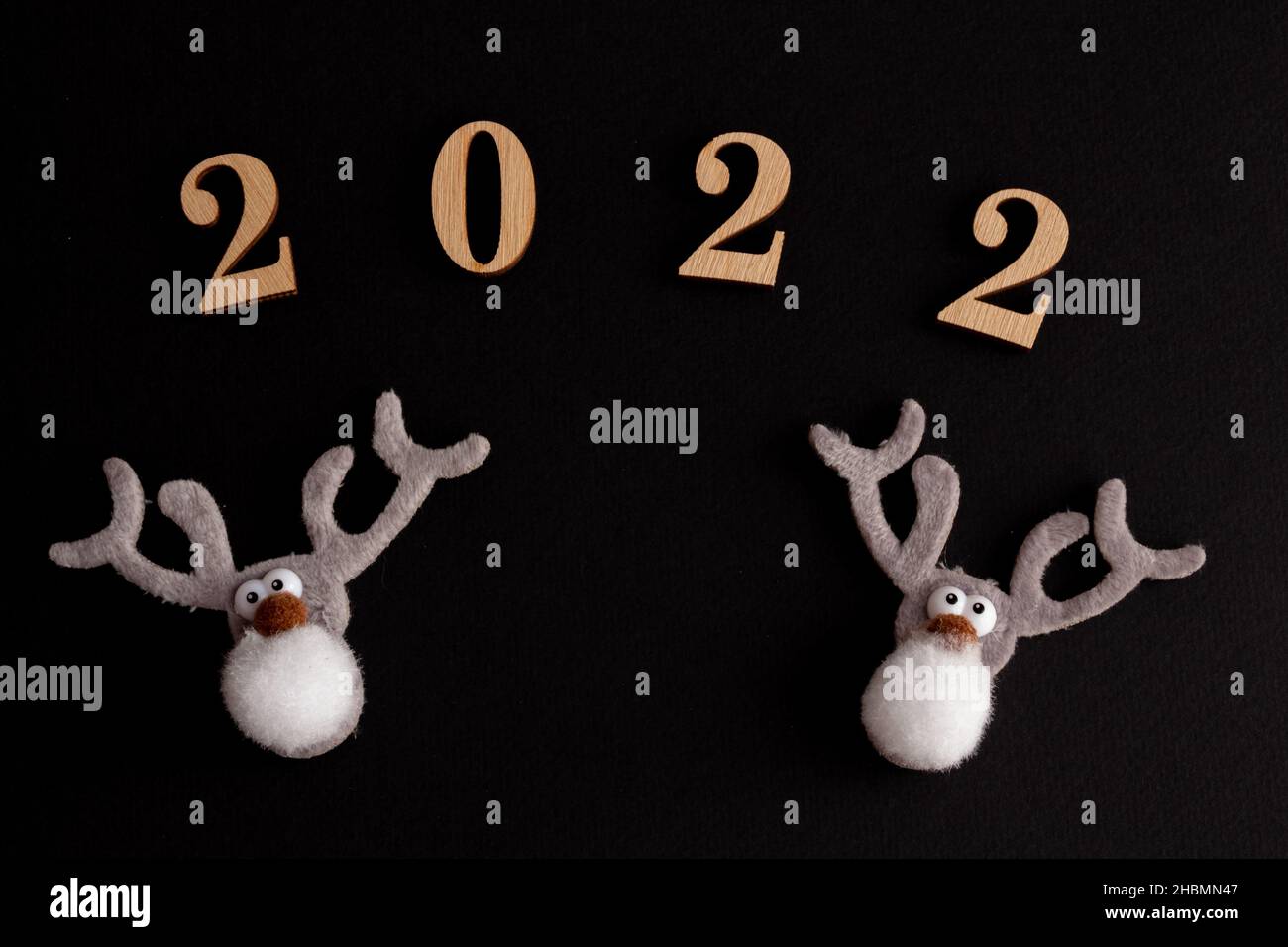 2022, christmas composition on a black background, funny gray deer, copy space Stock Photo