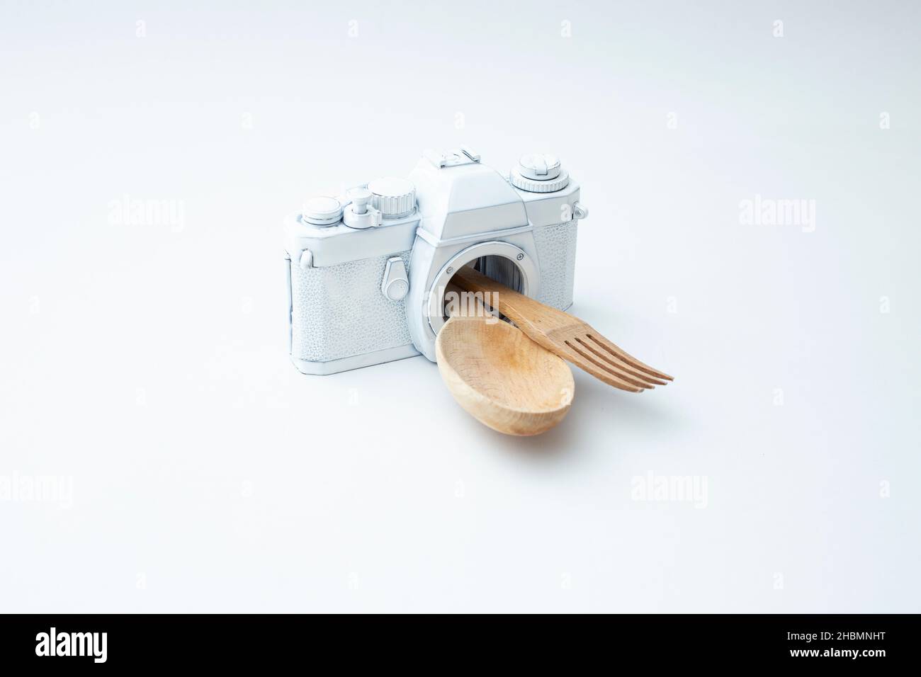 wooden spoon and fork coming out from a white vintage camera. Food photography concept. Stock Photo