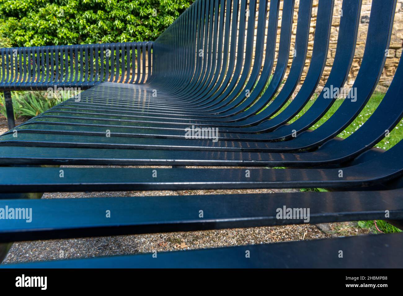 Close up view of a black painted metal slatted outdoor bench seat Stock Photo