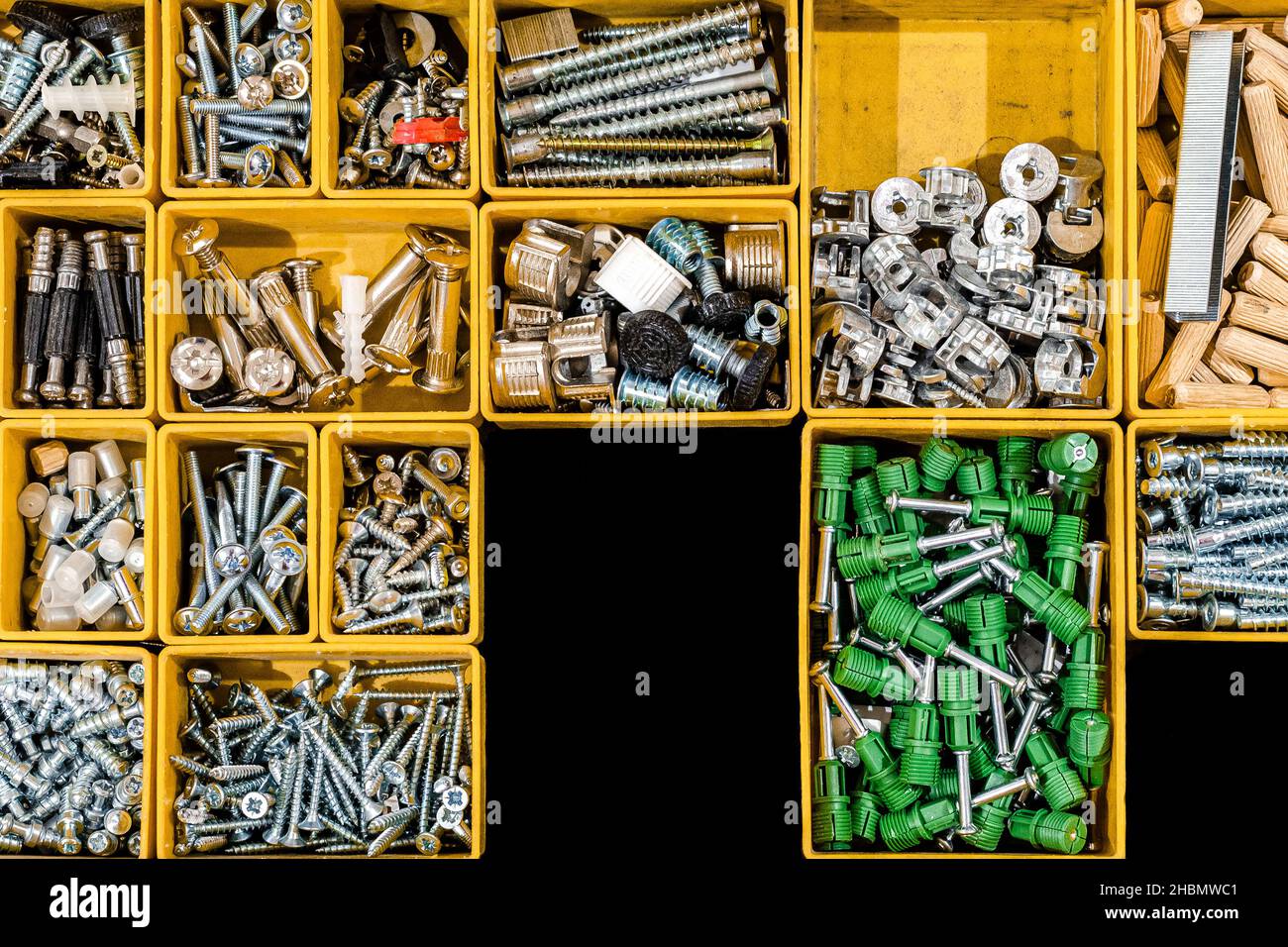A set of bolts and self-tapping screws for mounting and assembling furniture for home and office. Many storage compartments filled with builders acces Stock Photo
