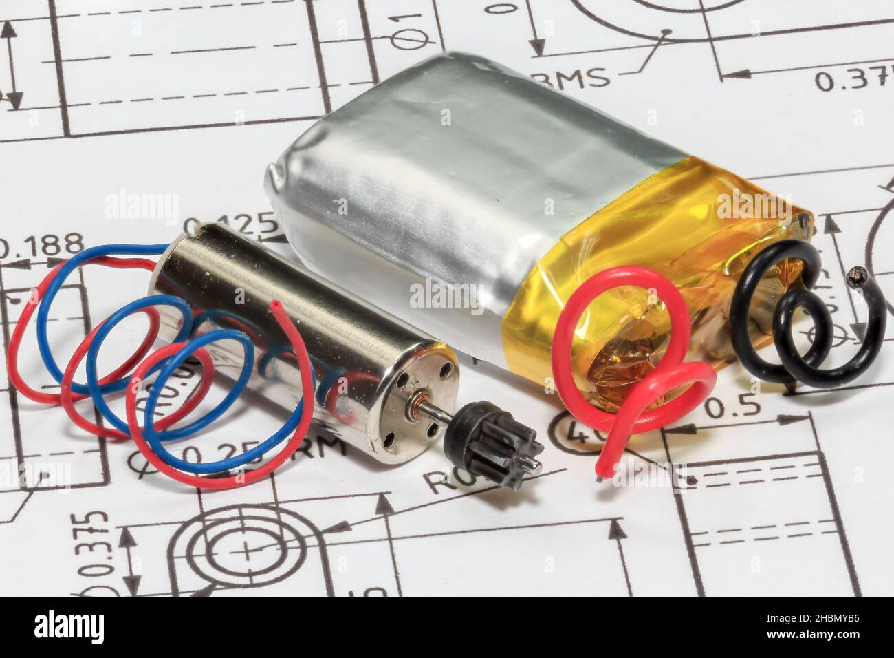 Closeup on a miniature electric motor, and battery placed on a