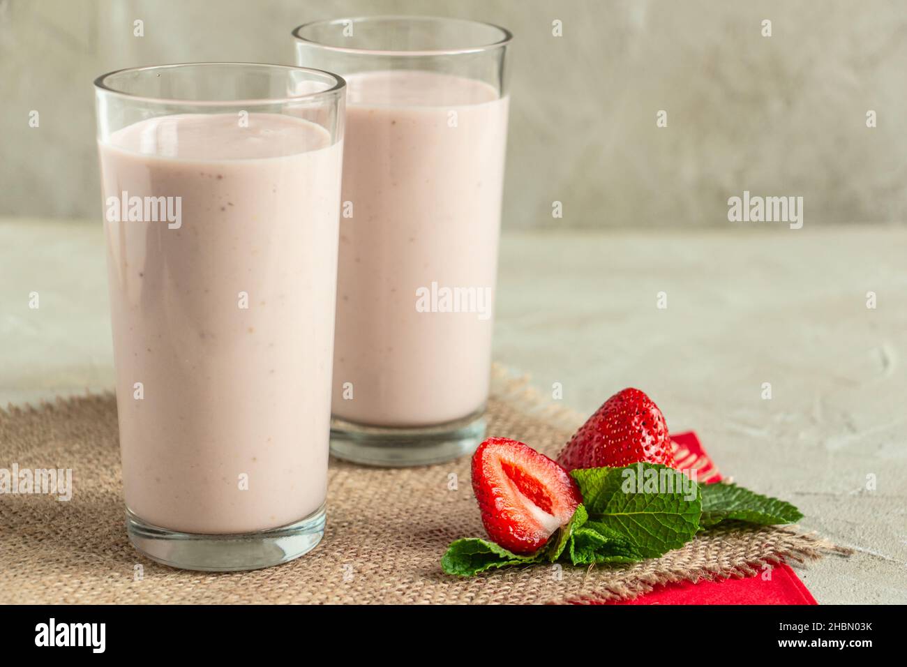 delicious milkshake with strawberries in tall glasses, strawberries and mint Stock Photo