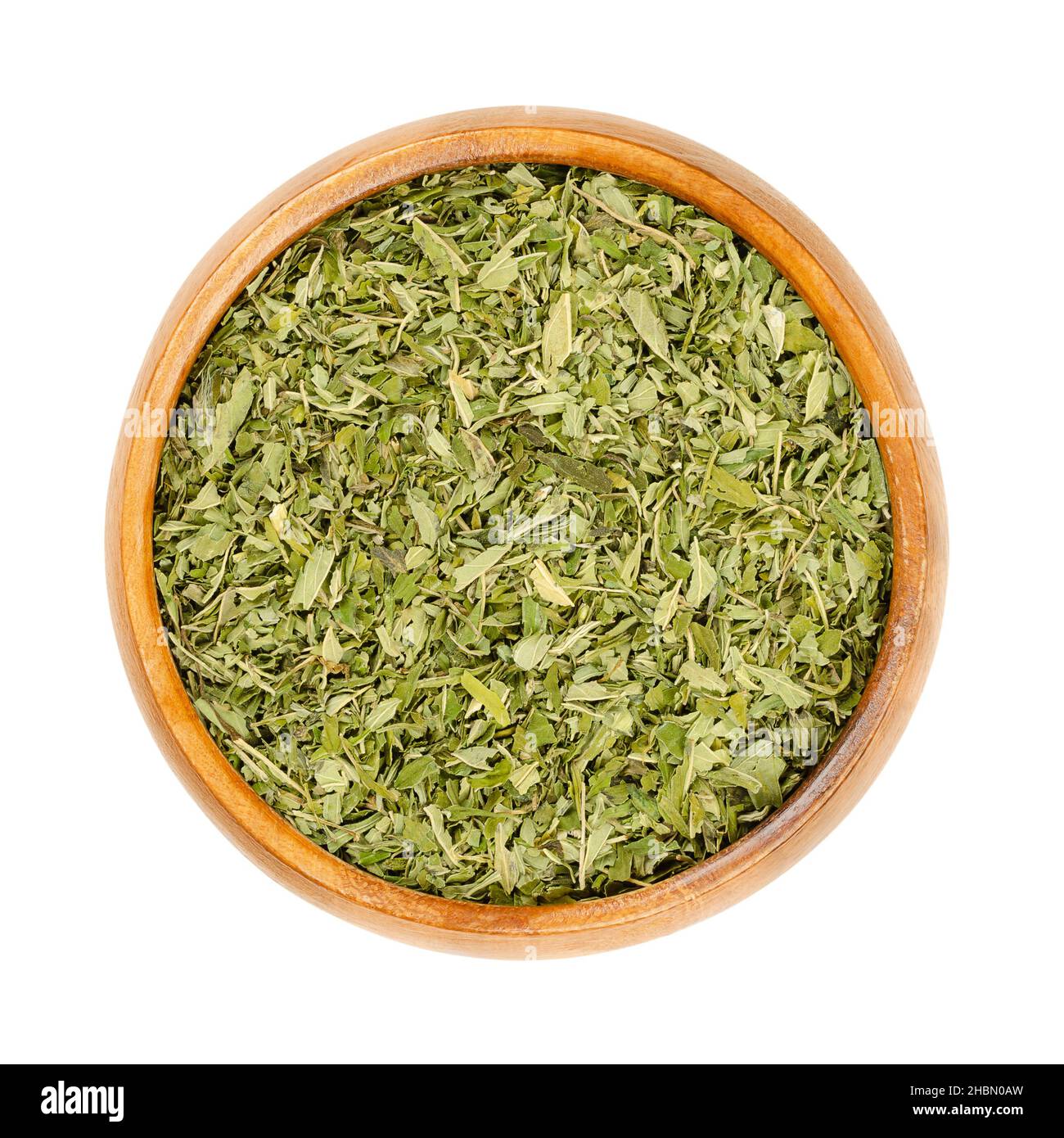 Hemp tea leaves, in a wooden bowl. Dried hemp leaves, Cannabis sativa, to be used as tea, spice, incense or as addition to the bath. Pure hemp leaves. Stock Photo