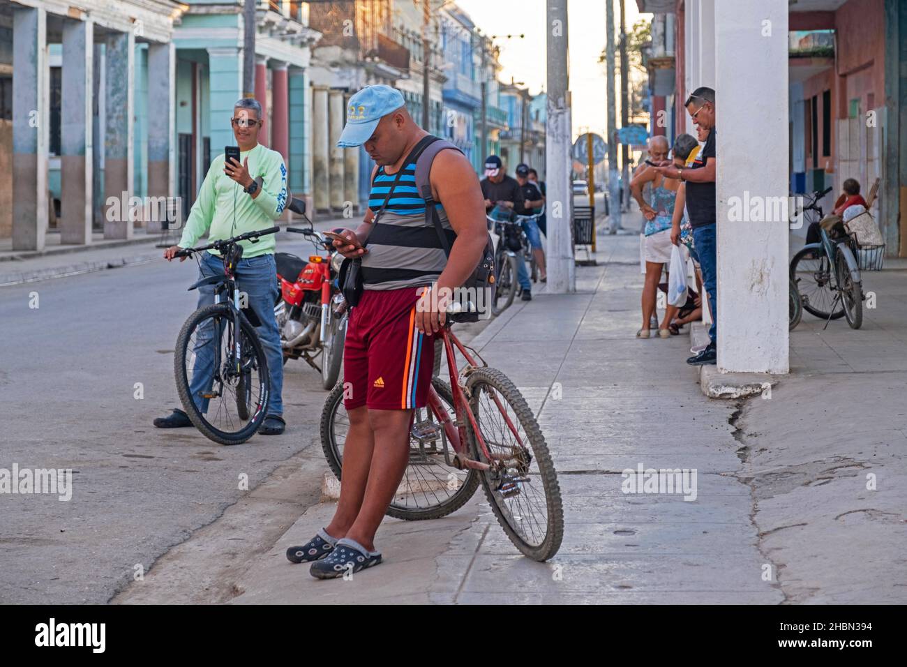 Group of local Cuban inhabitants trying to connect smartphones to the internet via Wi-Fi in the streets of Colón, Matanzas Province on the island Cuba Stock Photo