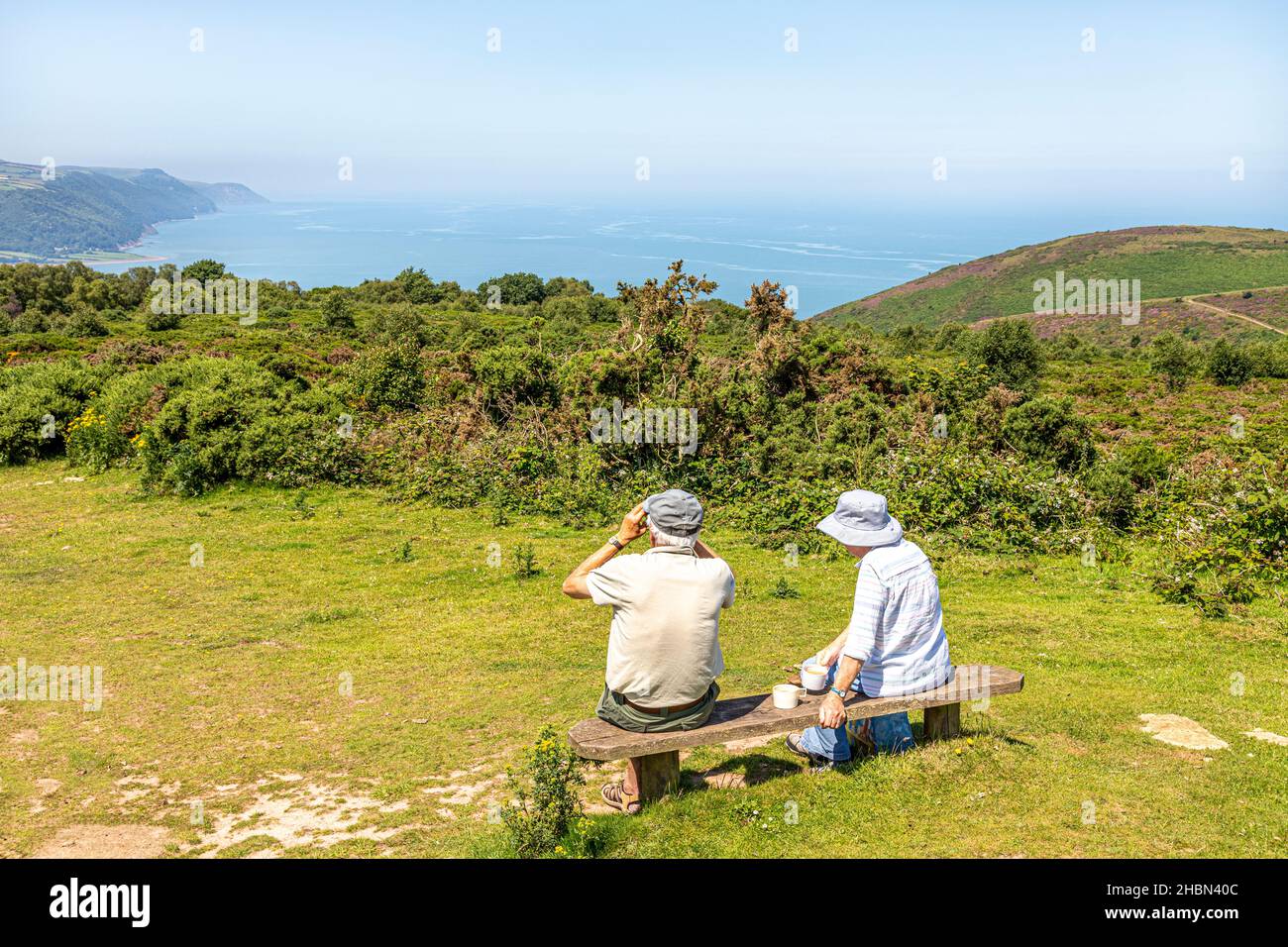An older couple enjoying the view of the North Somerset coast from the viewpoint of Selworthy Beacon on Bossington Hill near Minehead, Somerset UK Stock Photo