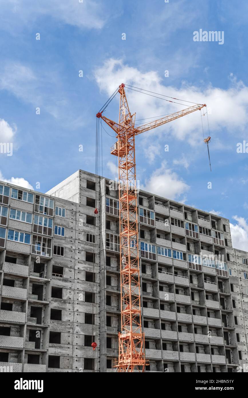 Building. Crane towering over the concrete structure. Stock Photo