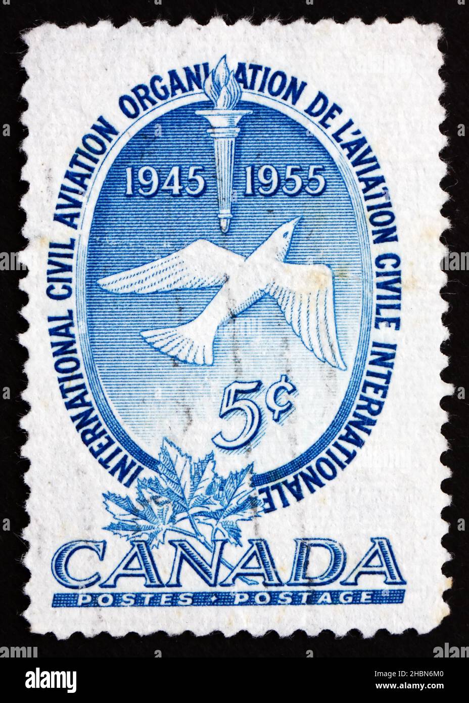 CANADA - CIRCA 1955: a stamp printed in the Canada shows Torch, Dove and Maple Leaves, 10th Anniversary of ICAO, circa 1955 Stock Photo