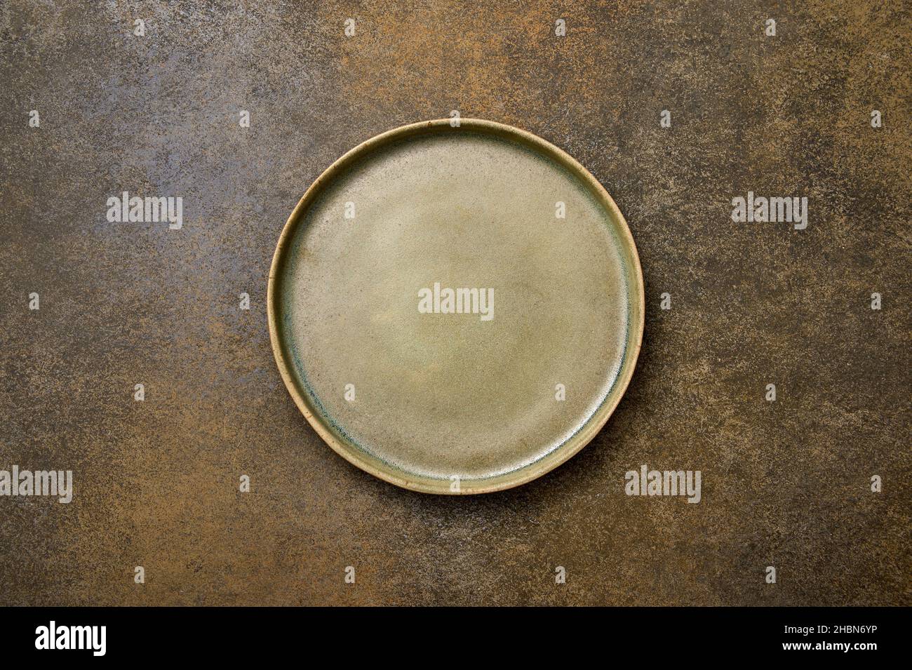Top view empty green ceramic plate on brown rustic background, copy space Stock Photo