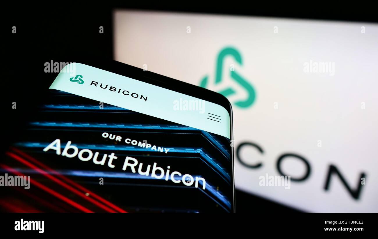Mobile phone with webpage of US software company Rubicon Technologies LLC on screen in front of business logo. Focus on top-left of phone display. Stock Photo