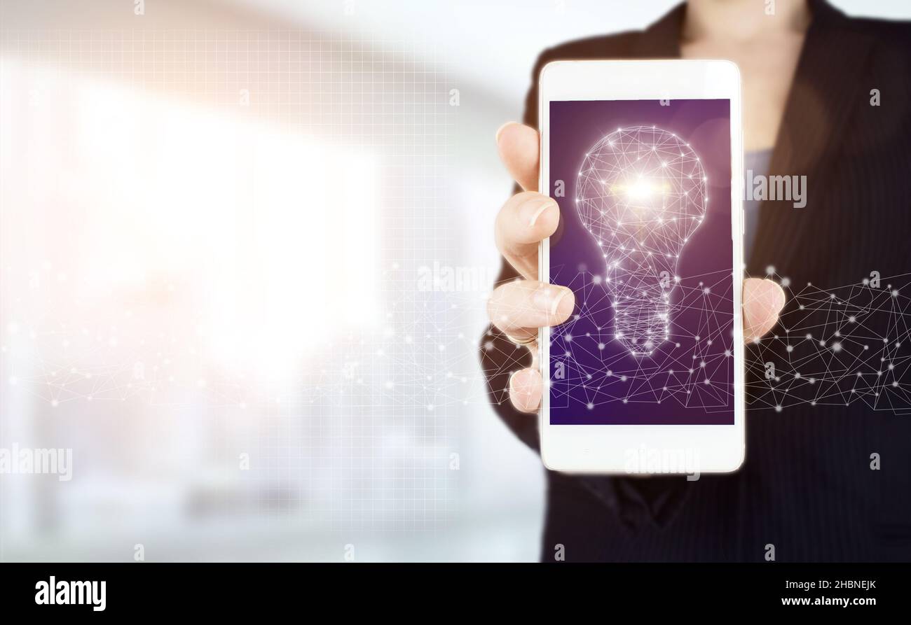 Network bright idea with light bulb. Hand hold white smartphone with ...