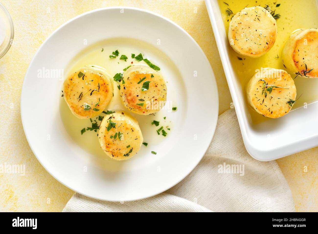 Fondant potatoes over light background. Baked potatoes in butter and
