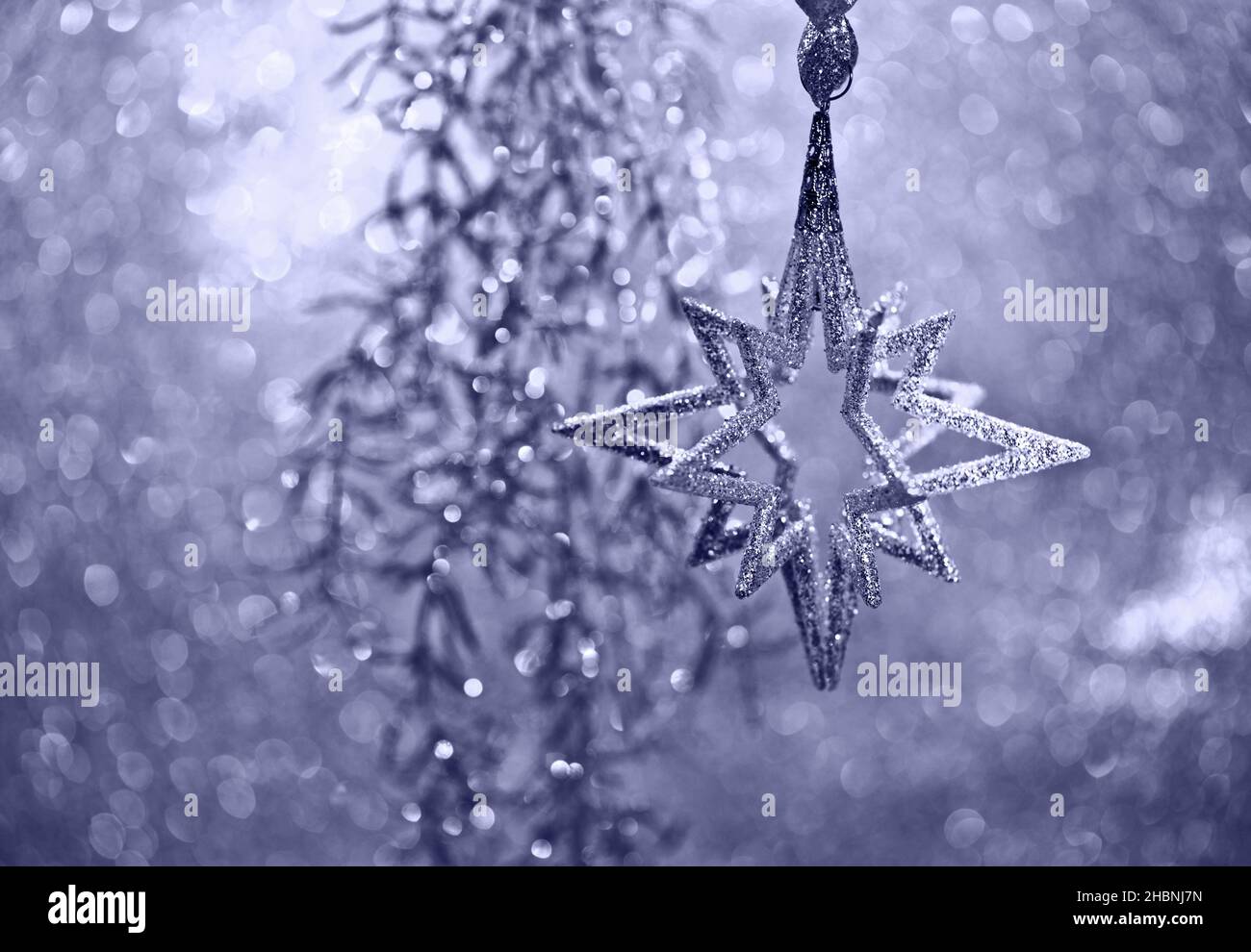 Christmas decoration silver star and lights on blurred violet background Stock Photo