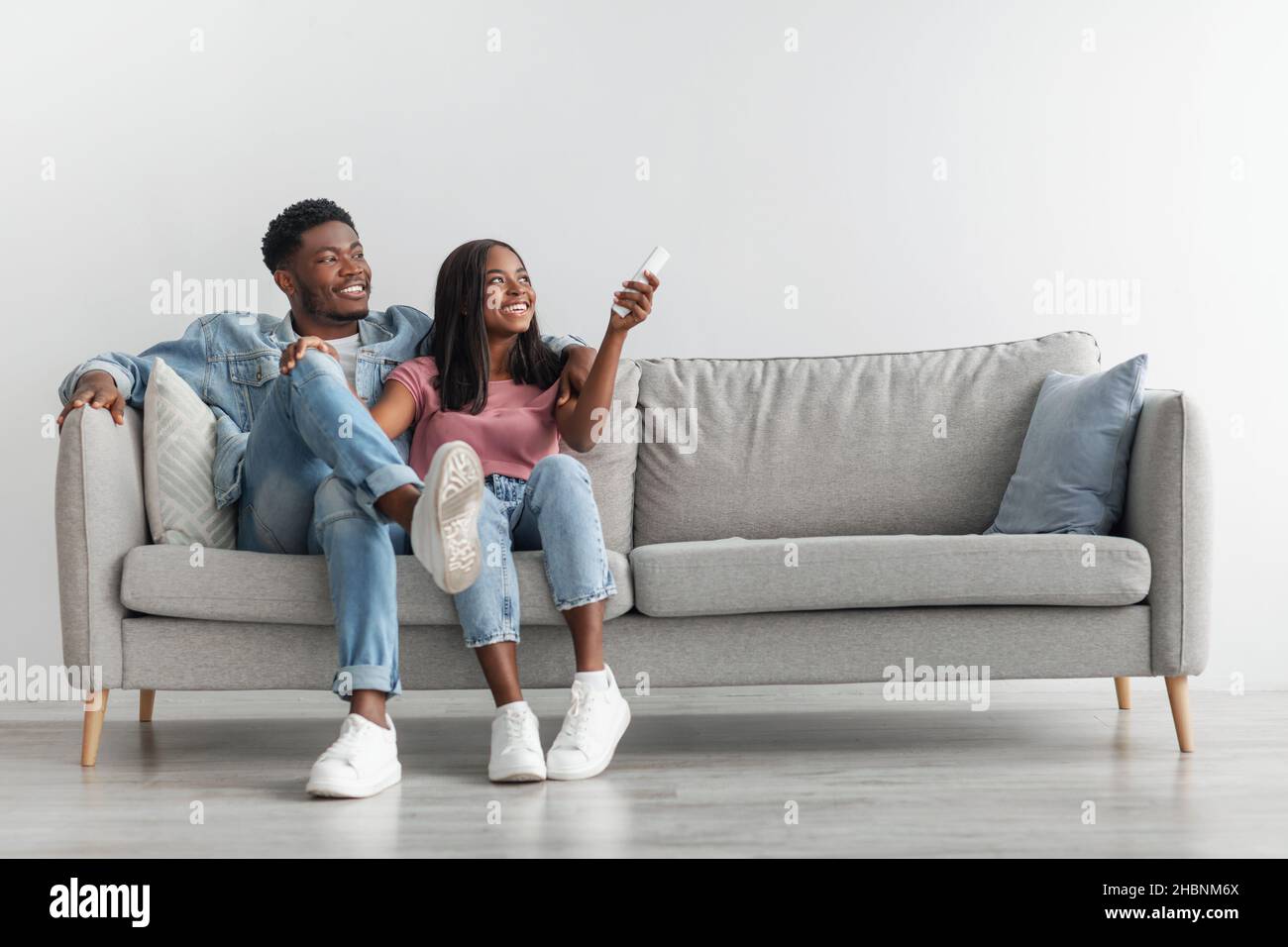 Young black woman switching on air conditioning at home Stock Photo