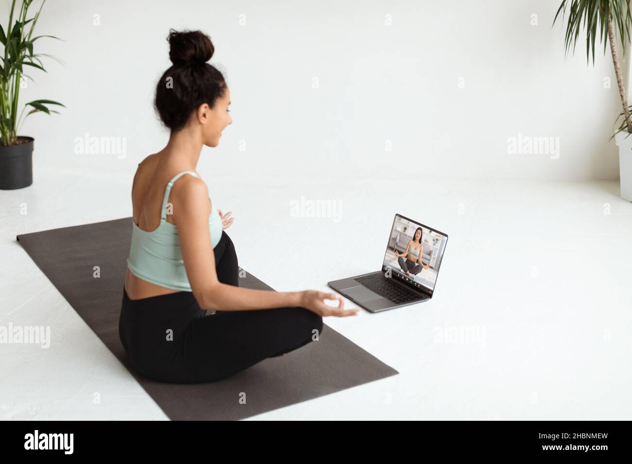 Online Yoga. Woman Having Video Conference With Instructor While Training At Home Stock Photo