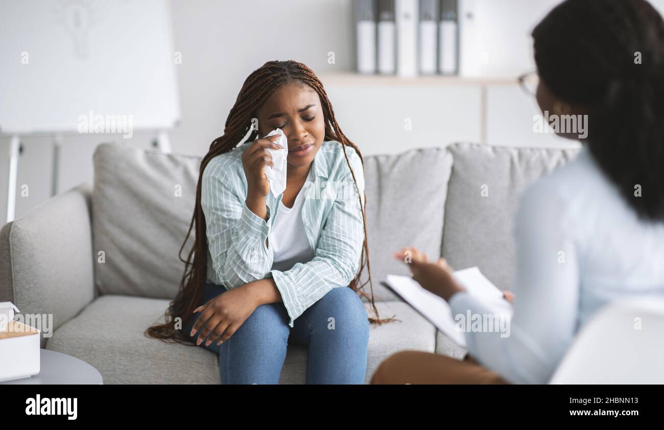 Unhappy black female client consulting psychologist, crying at medical ...